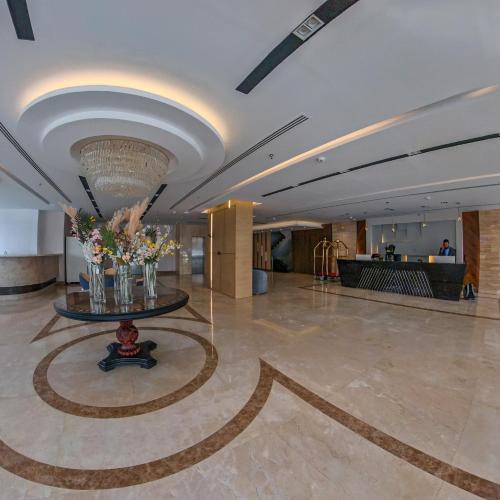 a lobby with a vase of flowers on the floor at SAMT INN HOTEL فندق سمت إن in Riyadh