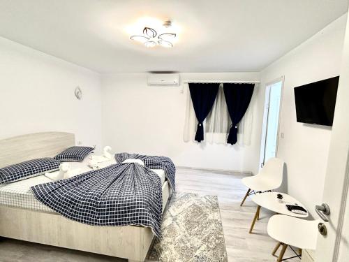 a white bedroom with a bed and a chair at Casa Munteanu in Mila Douăzeci şi Trei