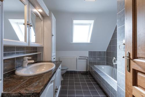 a bathroom with a sink and a tub at Villa Florentine in Oostduinkerke