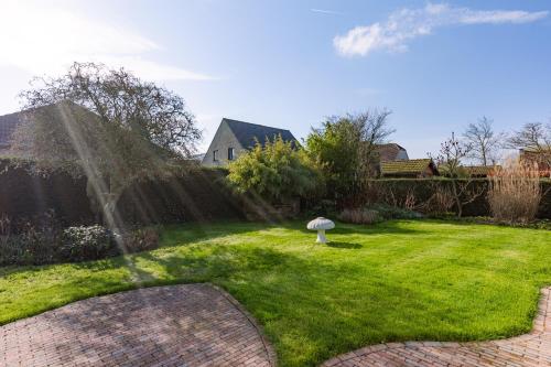 a garden with a fountain in the grass at Villa Florentine in Oostduinkerke