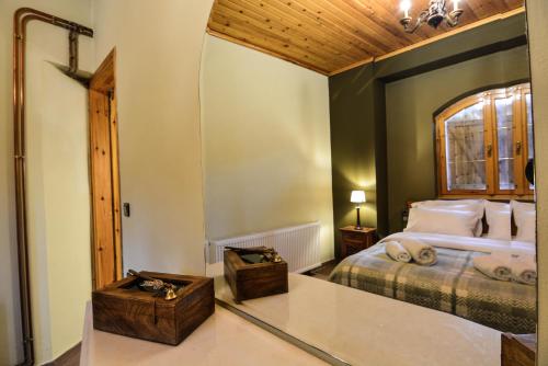 ein Schlafzimmer mit einem großen Bett und einem Fenster in der Unterkunft Capris Rustic Ηouse with Mountain View in Archaia Feneos