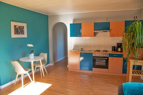 a kitchen with blue and orange cabinets and a table at Ferienwohnung Maintalblick in Eltmann