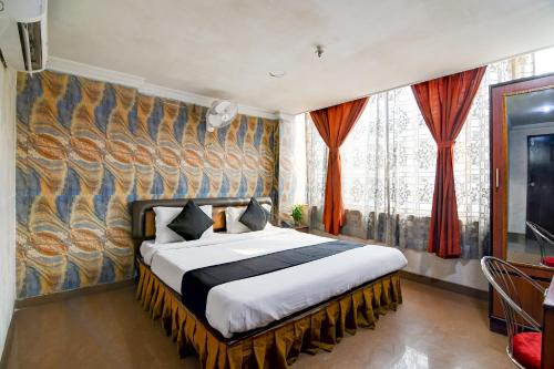 a bedroom with a bed and a large window at Raj Palace Near City Centre 2 in kolkata