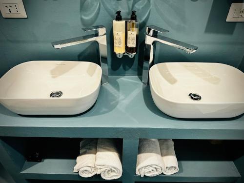 a bathroom with two sinks and towels on a shelf at Trastevere House in Rome