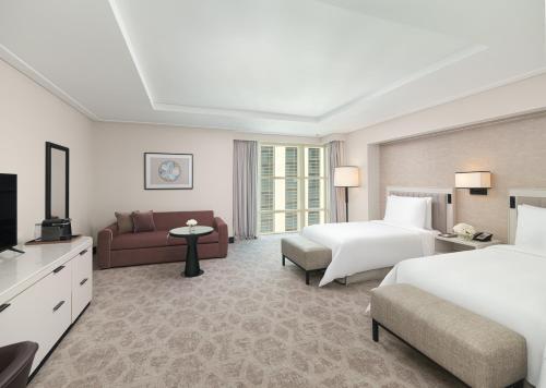 a hotel room with two beds and a couch at Address Jabal Omar Makkah in Makkah