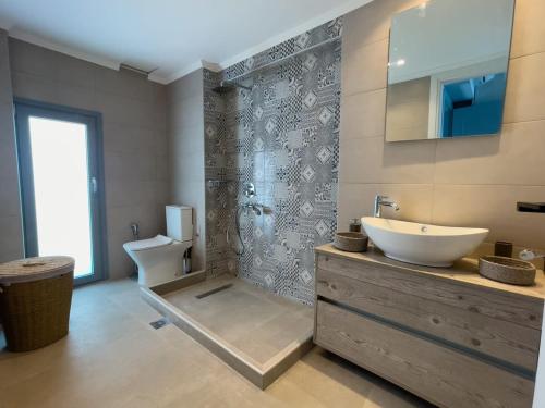 a bathroom with a sink and a toilet at Charaki Sea Breeze Modern Studio with Balcony in Haraki