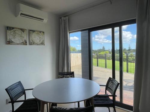 a white table and chairs in a room with a window at Relax by the Tamaki River in Auckland