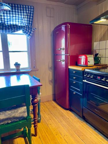 a kitchen with a red refrigerator and a table at Prästgatanett Apartments in Östersund