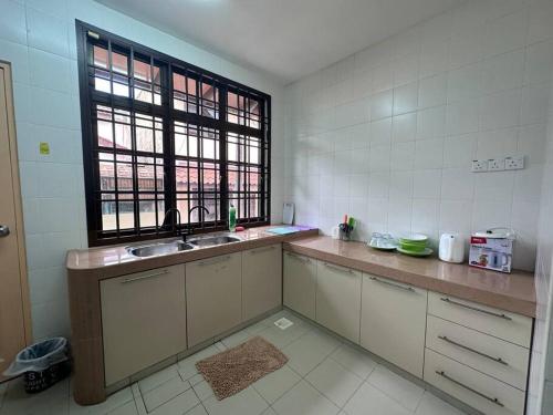 uma cozinha com um lavatório e uma janela em Pelangi Indah 8 Rooms Corner Pool Table em Ulu Tiram
