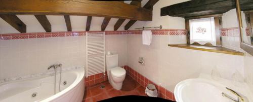 a bathroom with a tub and a toilet and a sink at Posada La Victoria in Miengo