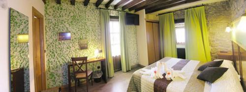 a hotel room with a bed and a table and window at Posada La Victoria in Miengo
