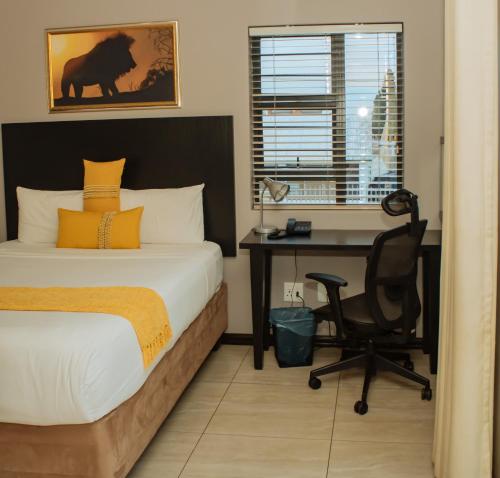a bedroom with a desk and a bed and a chair at Heavenly Boutique Hotel in Johannesburg
