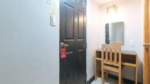 uma porta preta numa cozinha com um frigorífico em RedDoorz at Ranchotel Alabang em Manila