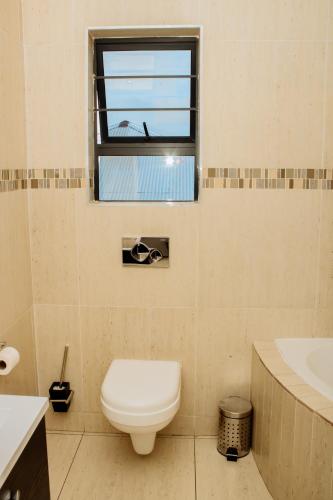 a bathroom with a toilet and a window at Heavenly Boutique Hotel in Johannesburg