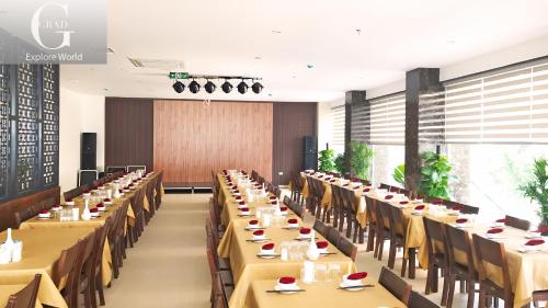une grande salle à manger avec de longues tables et chaises dans l'établissement 1986's Hotel, à Dong Quan