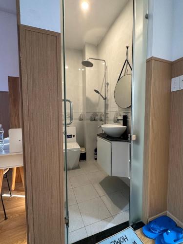 a bathroom with a shower and a sink and a toilet at Ham Homestay in Vung Tau