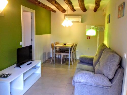 a living room with a couch and a tv and a table at Apartamentos Bergantes in Ortells