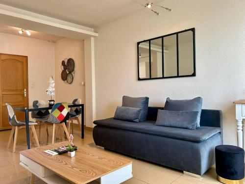 un salon avec un canapé bleu et une table dans l'établissement Résidence Investar appartement 4 Superbe T2 meublé, Gare 10mn à pied, à Montluçon