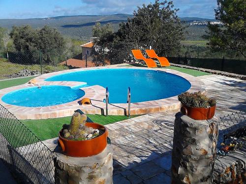 una gran piscina con sillas naranjas alrededor. en Bela Vista House - Quinta amoreira, en Benafim