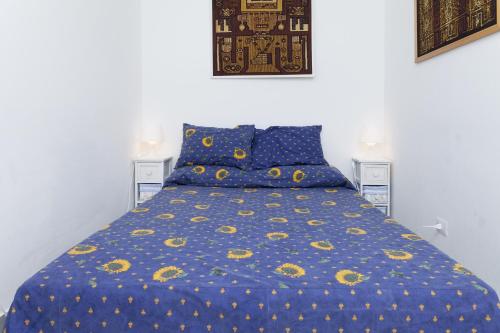a bed with a blue comforter and blue pillows at Holiday home Fiorita in Portovenere
