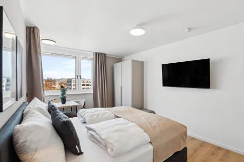a bedroom with a bed and a flat screen tv at Limehome Salzburg Sterneckstr in Salzburg