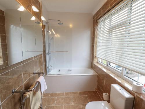 a bathroom with a tub and a toilet and a sink at Castle Top Haven in Market Rasen