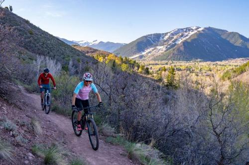 two people riding bikes down a dirt road at Chaparral Aspen Ranch Cabin in Woody Creek