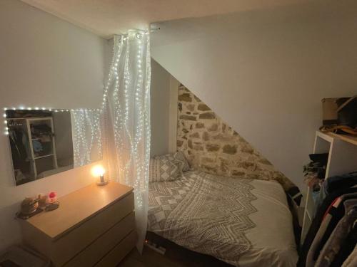 ein Schlafzimmer mit einem Bett und einer Kommode mit einer Kerze in der Unterkunft Jolie type 2 in Peynier