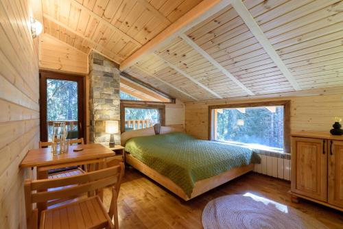 ein Schlafzimmer in einem Blockhaus mit einem Bett und einem Schreibtisch in der Unterkunft Life House-Semkovo in Belitsa