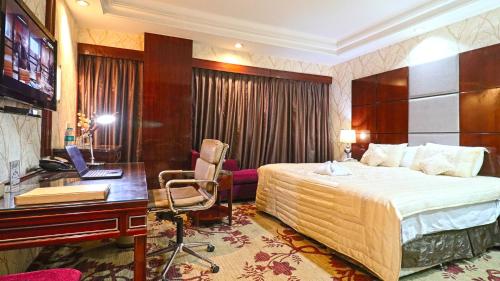 a hotel room with a bed and a desk with a computer at SkyCity Hotel Gurgaon in Gurgaon