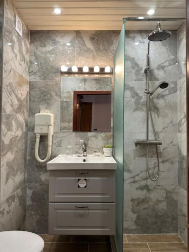 a bathroom with a shower and a sink at Hotel Art in Varna City