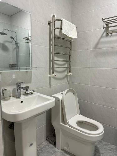 a bathroom with a white toilet and a sink at Silver Hotel in Samarkand