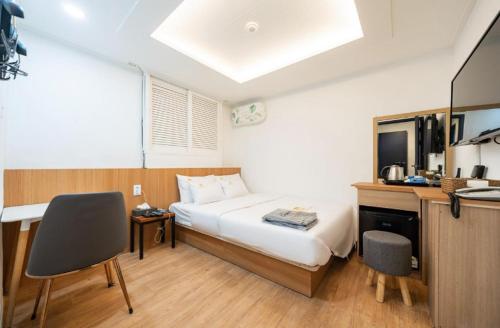 ein Schlafzimmer mit einem Bett und einem Schreibtisch sowie eine Küche in der Unterkunft Must Stay Mokdong in Seoul