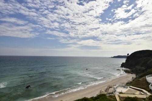 a view of a beach with people in the water at Shimoda Prince Hotel in Shimoda