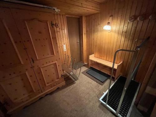 an empty bathroom with a wooden wall and a door at Ferienwohnung Lidia Badbruck in Bad Gastein