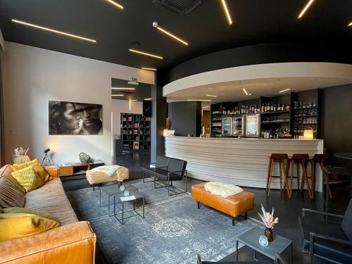 uma sala de estar com um sofá e um bar em Hotel Elisabeth em Mechelen