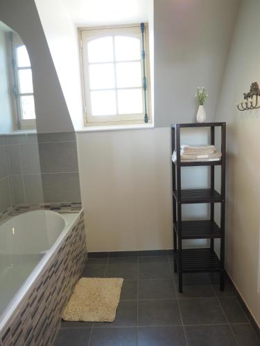 une salle de bain avec une baignoire et une fenêtre dans l'établissement Les Grands-Aulnais, à Cossé-le-Vivien