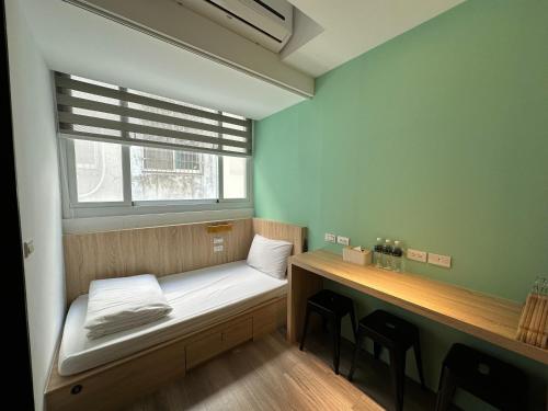 een kleine kamer met een bed en een raam bij 澎湖 居墅 in Magong