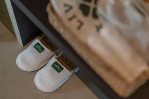two pairs of white shoes sitting on the floor at Shamrock Chiangmai Hotel-Adult Only in Chiang Mai