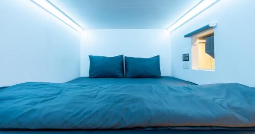 a bed in a white room with a window at Bobopod Thamrin, Jakarta in Jakarta