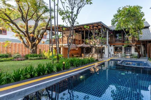an image of a swimming pool in front of a house at Shamrock Chiangmai Hotel-Adult Only in Chiang Mai