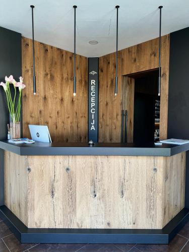 a bar with a wooden wall with a laptop on it at Hiša Aleš in Kranj