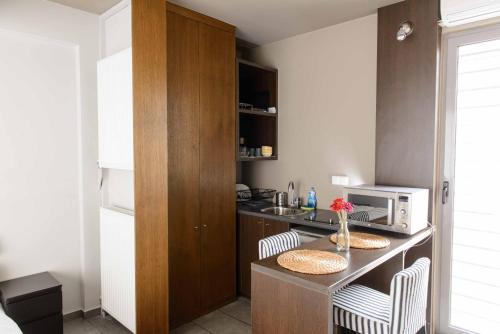 een keuken met een aanrecht met 2 stoelen en een magnetron bij Bright Loft With Terrance - Next to Metro Kerameikos in Athene