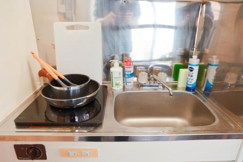 大阪市にある龙猫民宿-梅田店403のキッチン(シンク、コンロの上に鍋付)