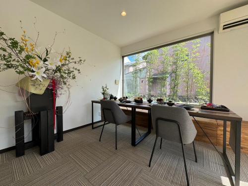 a dining room with a table and chairs and a large window at アナザースカイ京都二条城 in Kinugasa