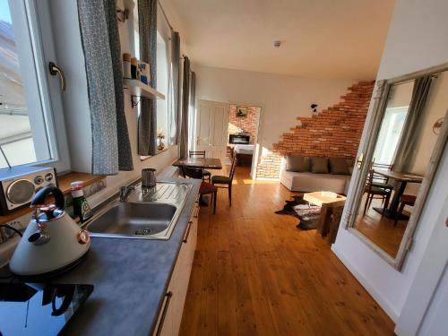a kitchen with a sink and a living room at Dolný apartmán H11 Banská Štiavnica in Banská Štiavnica