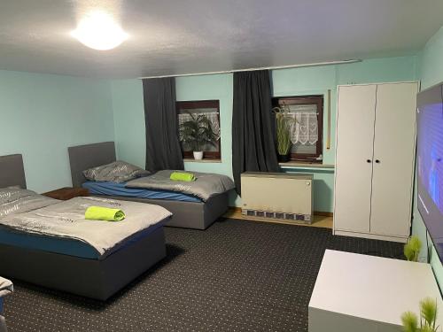 een kamer met 2 bedden en een flatscreen-tv bij Chambre avec 3 lits in Trier