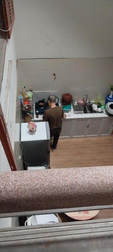 Un uomo in piedi in una cucina in una stanza di BiBon a Ðoan Xá