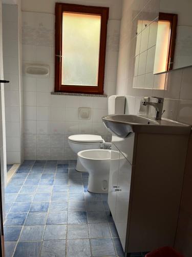 ein weißes Bad mit einem WC und einem Waschbecken in der Unterkunft Appartamenti Rena Majore in Aglientu