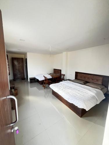 a bedroom with two beds and a table in it at Green Beats in Pune